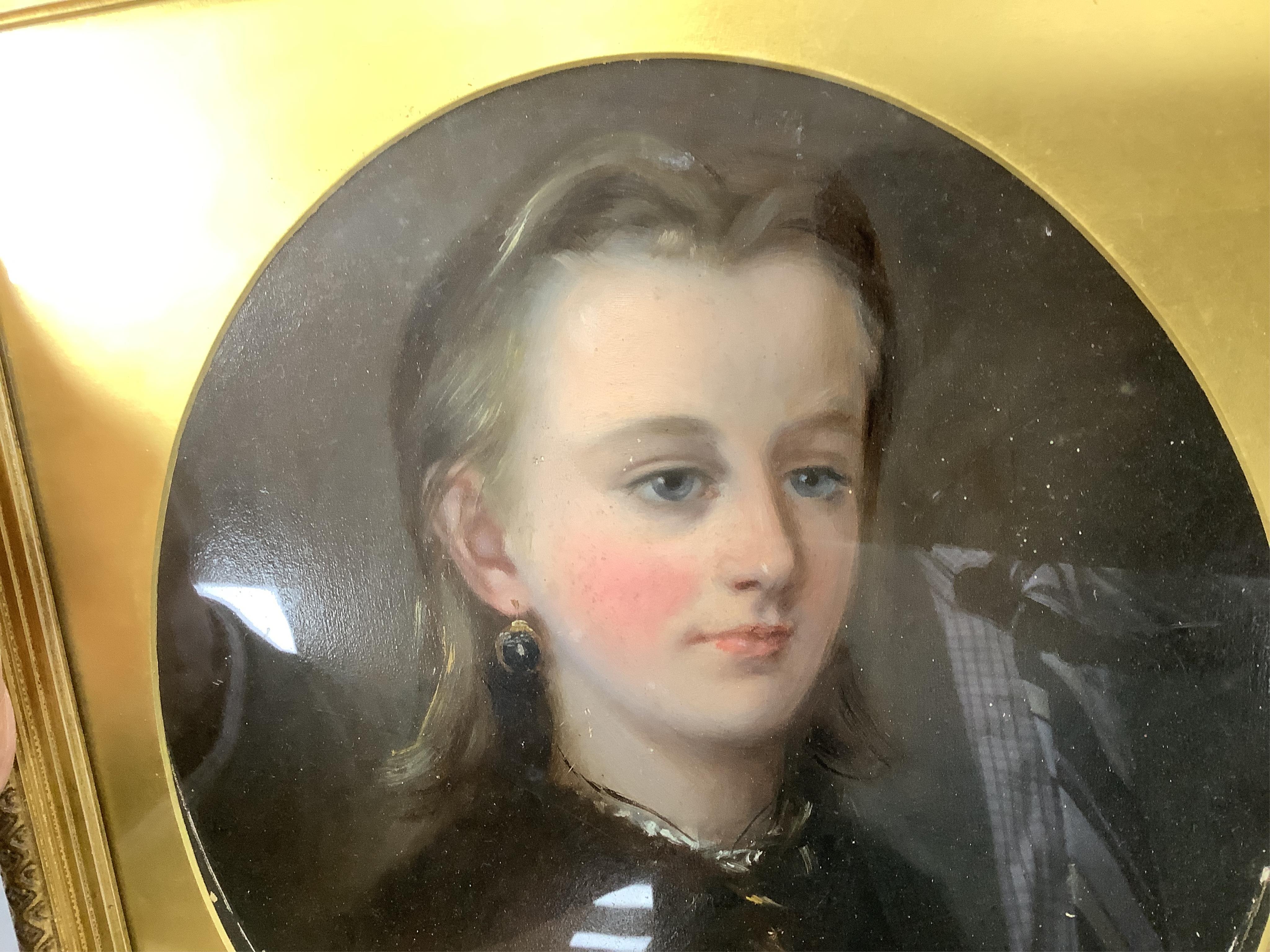 19th century, Naïve school, oval oil on board, three quarter length portrait of a lady, gilt framed, together with a similar portrait of a girl wearing garnet earrings, largest 34 x 24cm